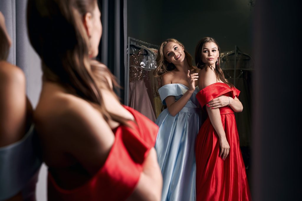 deux jeune femme avec une robe rouge en satin et une robe blanche en satin